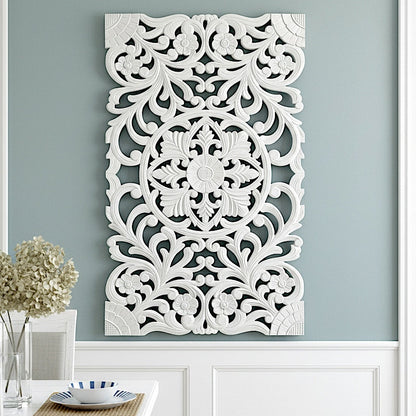Decorative white wall panel with intricate patterns on a light blue wall.